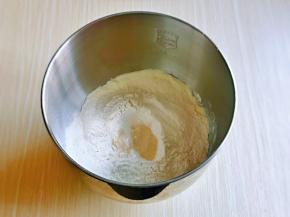 加入奶粉，高筋面粉，面粉上面挖个洞加入酵母粉，再盖起来，启动厨师机揉面一个程序。