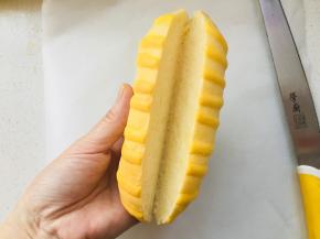 出炉后自然摊凉，中间卡仕达酱装入裱花袋中，挤入到中间位置。在装饰上黄桃，撒上一些防潮糖粉即可切开