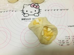 因为奶酪丁的体积比较大，包裹时要拎起四角才比较好包裹住，包好后，开口向下，进行2次发酵，2发时间60分钟左右，湿度75%，温度30