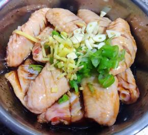  放入切好的葱姜蒜放入鸡翅一起拌匀盖上保鲜膜放入冰箱冷藏六小时