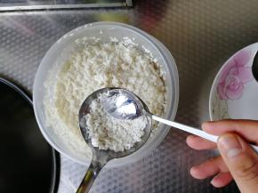 用小勺子将调好味道的米放入汤勺里，略微压平。不需要太厚。