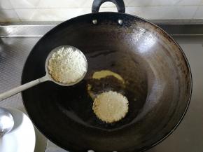 炸到略微变色，定型了。将之前舀米的小勺子擦干或者另外拿一个小勺子，沿着汤勺的边边，把定型的锅巴慢慢铲下来，铲入锅里。看。然后继续炸。