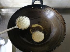 炸到略微变色，定型了。将之前舀米的小勺子擦干或者另外拿一个小勺子，沿着汤勺的边边，把定型的锅巴慢慢铲下来，铲入锅里。看。然后继续炸。