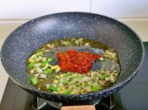 炒出香味儿后加入豆瓣酱小火翻炒。