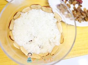 把糯米饭压在上面这样红枣葡萄干就固定住了，在上面一圈再围一个红枣边