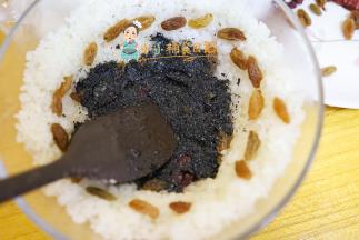 放上一层黑芝麻馅 旁边撒葡萄干跟蔓越莓