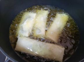 炸锅内倒入多一点的食用油烧热，放入做好的春卷。