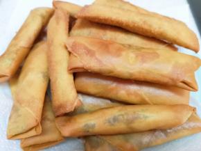 盘子里铺上厨房用纸，放上炸好的春卷吸一下多余的油分。