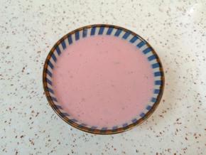 将打好的草莓奶昔倒入碗里。