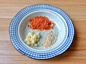 碗里放入蒜泥、白芝麻、辣椒面。