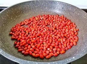 锅里放油倒入花生米，开中小火翻炒。