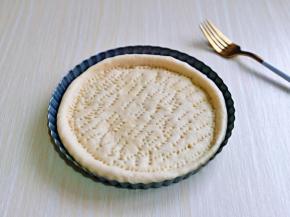 取一块面团，用擀面杖擀圆饼，与自己的披萨盘一样大小即可哈，再用食品叉扎出不规则的洞洞眼。