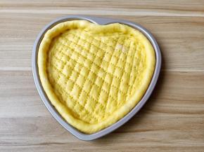 面团轻轻排气，将面团放入模具，四遍整理好形状，用叉子叉上小孔。