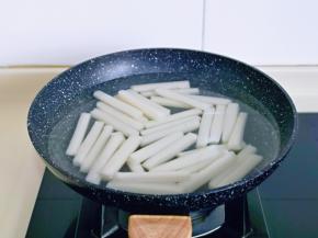 年糕洗干净后倒入锅中，水量没过年糕为佳，烧开煮2–3分钟，(冷藏过的年糕最好开水烫煮一下，这样做出来的辣炒年糕口感才会好）