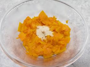 蒸熟的南瓜片从蒸锅里取出，放入盆里晾至温热，加入发酵粉用勺子压成南瓜泥。