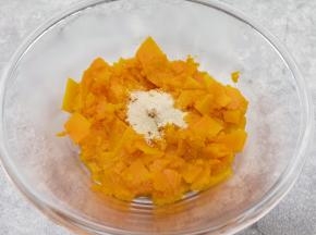 蒸熟的南瓜片从蒸锅里取出，放入盆里晾至温热，加入发酵粉用勺子压成南瓜泥。