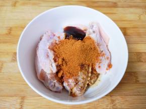 准备好的鸡中翅放入大碗里，加入烤肉料、蚝油和生抽。