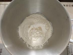 除了盐和黄油，其他材料放入厨师机打面桶，酵母在粉类上挖洞放入。