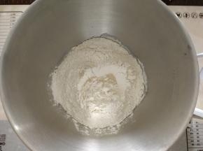 除了盐和黄油，其他材料放入厨师机打面桶，酵母在粉类上挖洞放入。