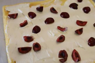 均匀地抹在蛋糕反面，樱桃洗净去核，切小块放在奶油上。