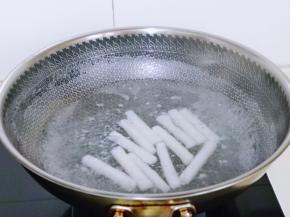 年糕洗干净后倒入锅中，水量没过年糕为佳，烧开煮2，煮好的年糕捞出放冷水中浸泡，这样使年糕更有韧性，口感更好。
