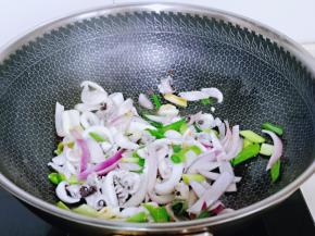 再加入焯水的鱿鱼，料酒翻炒均匀。