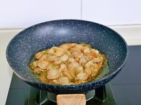 平底锅中加入食用油，油温八成热倒入静置好的扇贝肉，用铲子摊平，小火慢煎。