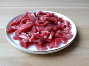 切好的牛肉丝放入盘里。