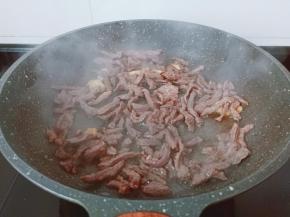 翻炒到牛肉丝变色。