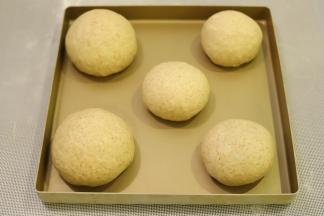 面团取出轻压排气，平均分成2大份，一份分成2小份，一份分成3小份。分别搓圆，静置15分钟。