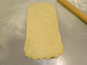 取一小份面团，擀成牛舌状，底部压平。