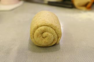 再次上下擀成牛舌状，翻面，从上往下卷好。