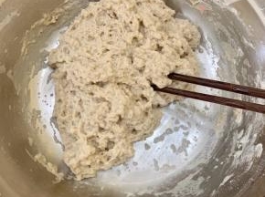 将温水慢慢倒入面粉里，边倒边搅拌。