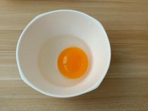 鸡蛋嗑入碗里。