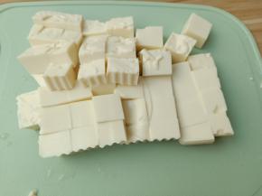 豆腐对半切开，再切成小块。