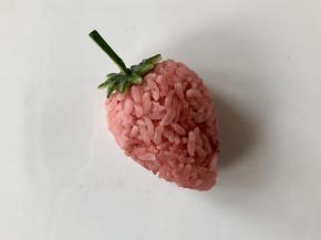 把用黄瓜皮做好的草莓蒂插到草莓饭团顶部。如果粘不紧，可以借助牙签或者意大利面（没煮之前硬的面干）。