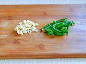 大蒜去皮切蒜末，青椒洗干净去根，去籽再切丝。