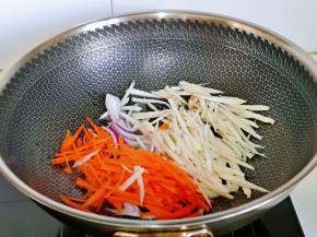 起油锅，加入蒜末炒香，再加入杏鲍菇丝，胡萝卜丝，洋葱丝煸炒。