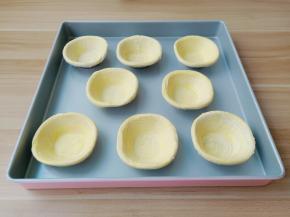 蛋挞皮依次码到烤盘上。