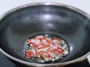 起油锅，加入蒜炒香，再加入切好的腊肠煸炒，加入料酒去腥。