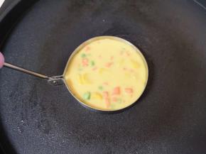 电饼铛预热（只开下盘），刷上一层玉米油，煎蛋模具里面也刷上一层食用油，放入电饼铛一起预热，预热完成以后，舀一勺玉米鸡蛋糊倒入煎蛋模具里面。
