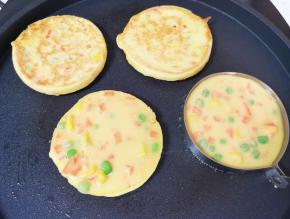 等到鸡蛋糊凝固以后，将煎蛋模具取开，饼翻面煎另一面，继续做下一个玉米鸡蛋饼。