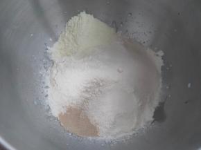 除黄油、盐外的全部食材放入厨师机面桶内，启动厨师机，先一档3分钟把食材混合均匀，转2档15分钟，把面团打至粗膜的状态。