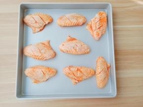 鸡翅依次码到烤盘上。