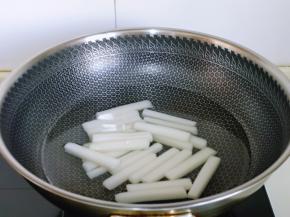 年糕冷水下锅，烧开煮1分钟，捞出过冷水。