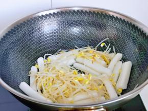 另起油锅，加入焯水的豆芽，年糕煸炒。