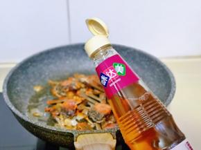 带毛蟹表面变为红色时，加入料酒翻炒。