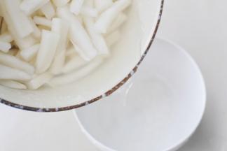 腌好的白萝卜倒出多余的盐水。