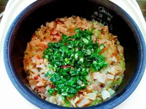 水份基本收干时放入青菜叶，搅拌均匀，盖盖继续焖煮，转保温后再焖十分钟出锅。