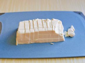 将豆腐倒扣在砧板上，再切小块。